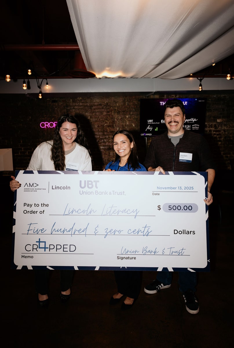 Three people holding large check
